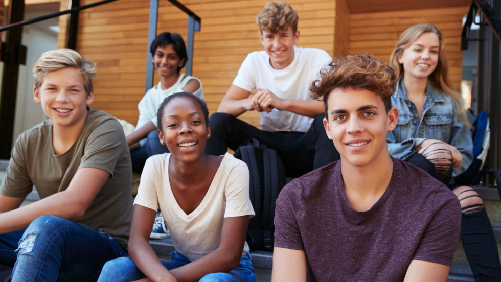 Six students sat on outdoor steps 