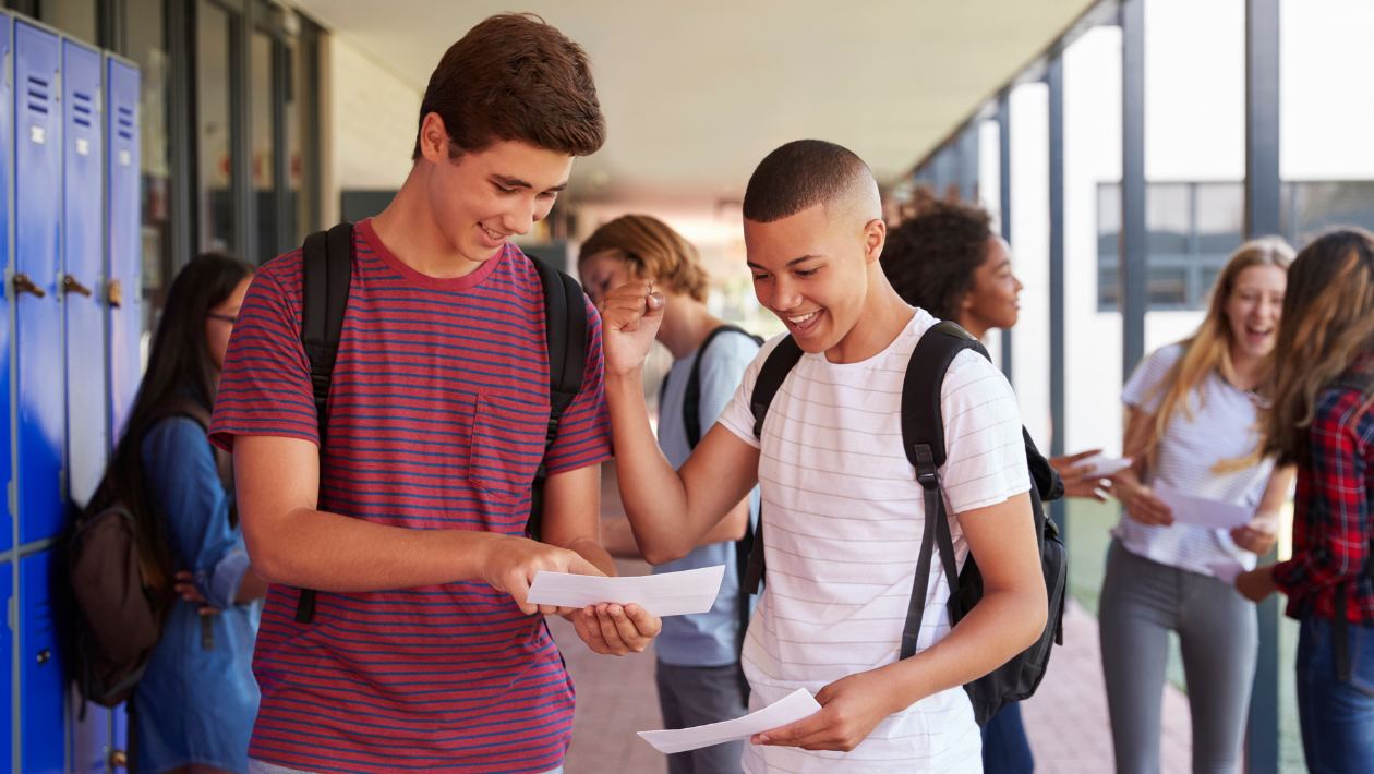 two happy young people reading exam results together