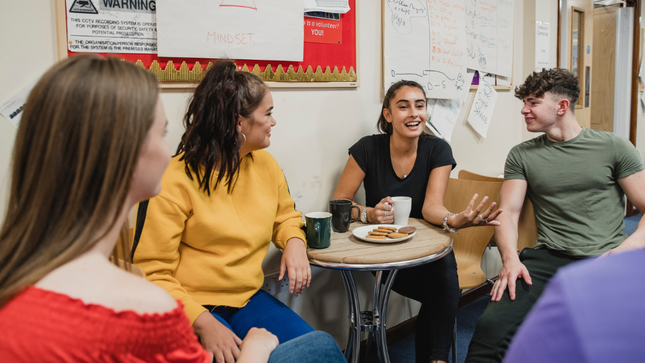 Four young people sat talking together