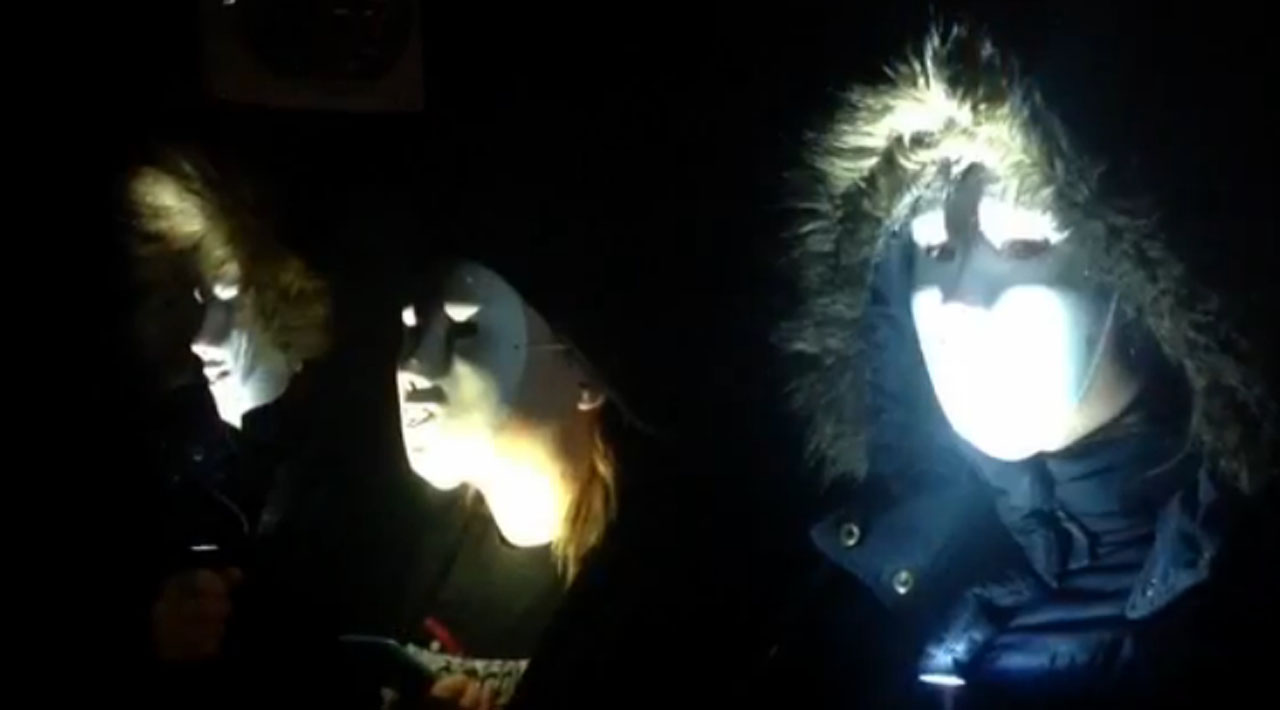 Three people in coats and white masks