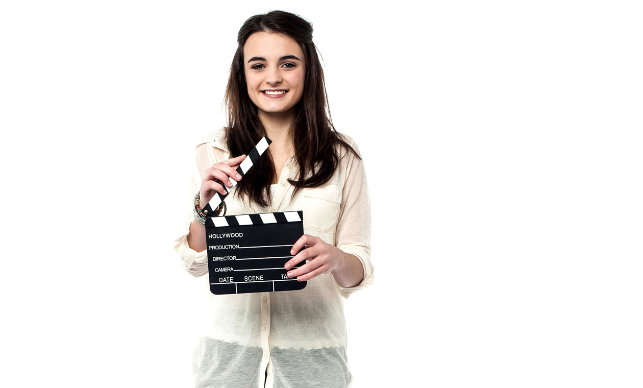 A young woman holding a clapperboard