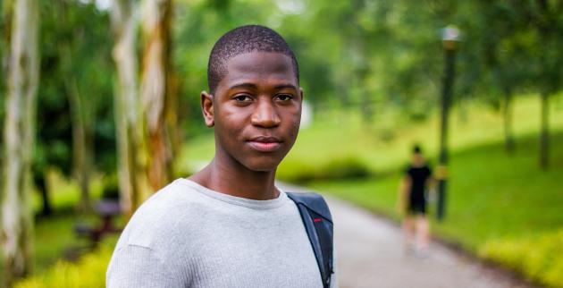 Young man in a park, looking towards camera