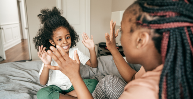 Mother and daughter clapping hands