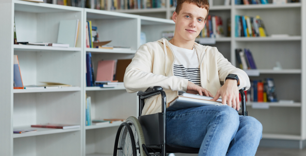 a teenaged wheelchair user smiling for the camera