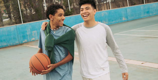 Two happy friends outside with a basketball