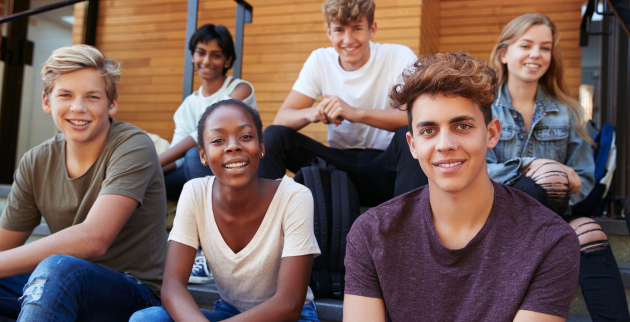 Six students sat on outdoor steps 