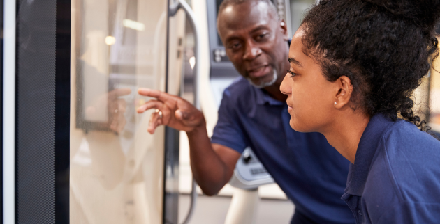 Young person being shown machinery at work by manager