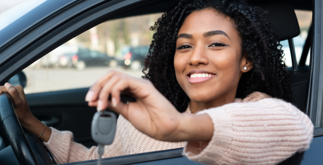young person sat in a car holding car keys
