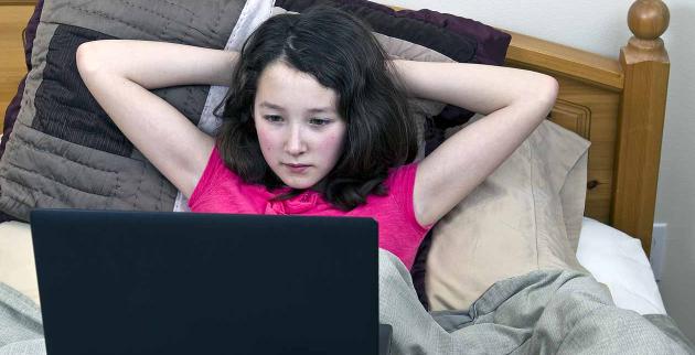 Girl on computer in bed