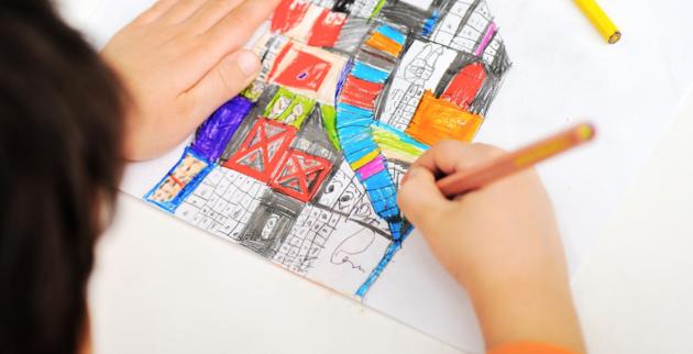 Looking over a child's shoulder as they draw a house