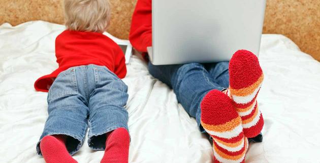 Two young people using a lap-top and a tablet to browse websites