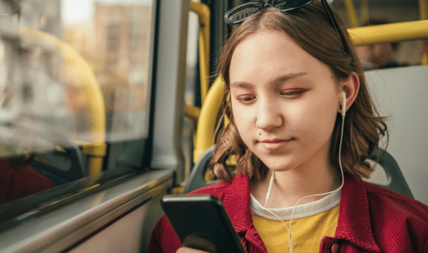 young person on bus using phone