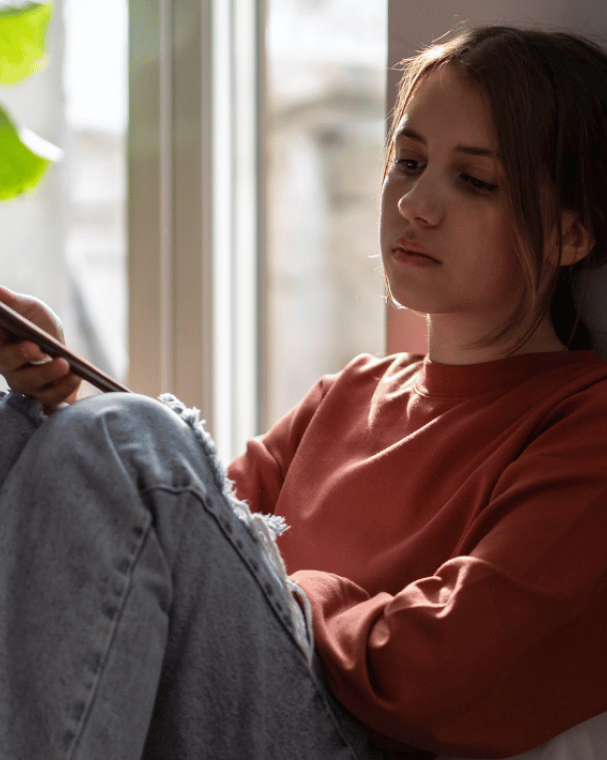 young person sat by window