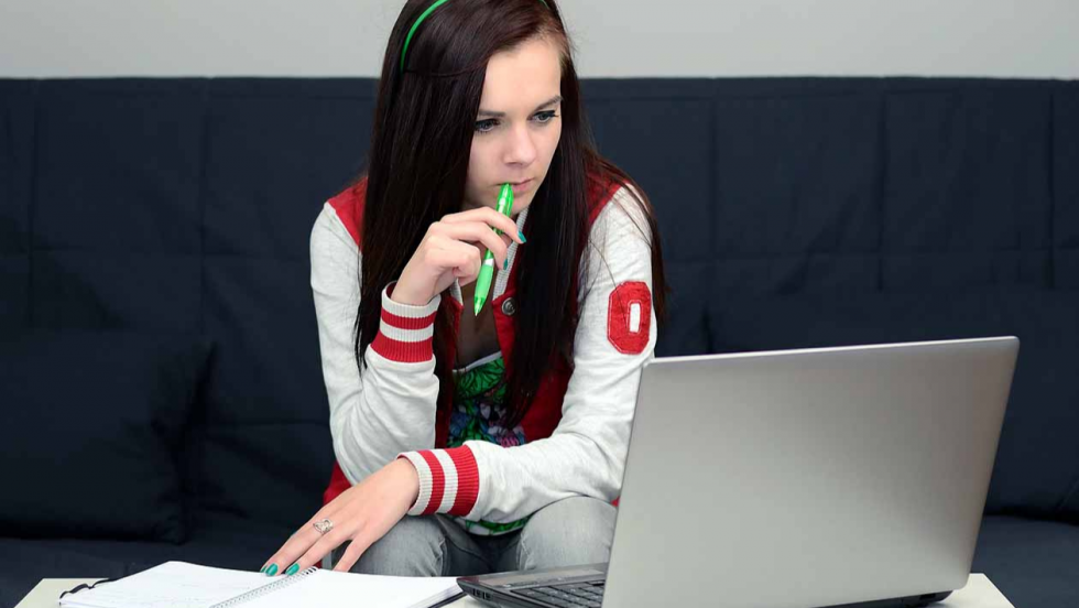 girl sat at laptop  