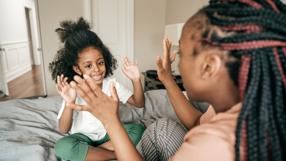 Mother and daughter clapping hands