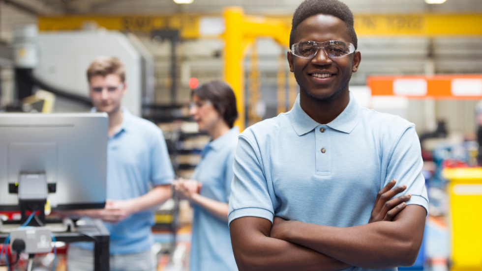 Young person at work wearing protective goggles and posing for the camera