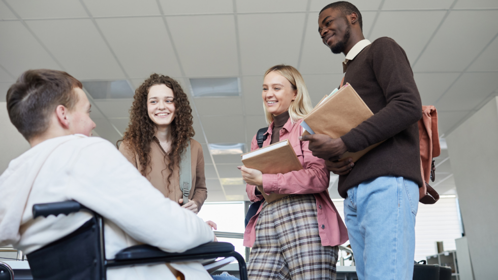 A group of young colleagues talking together, one is a wheelchair user