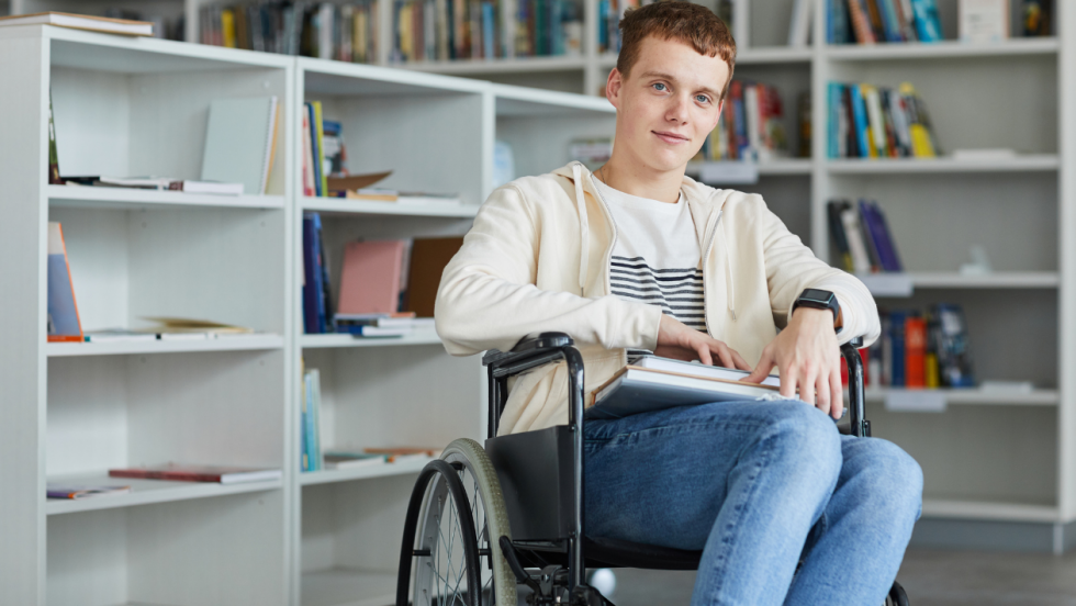 a teenaged wheelchair user smiling for the camera