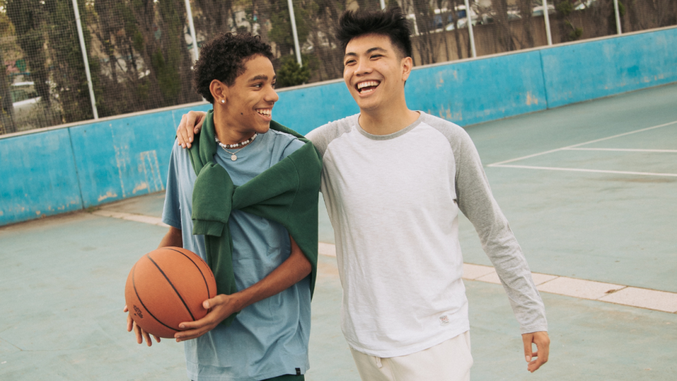 Two happy friends outside with a basketball