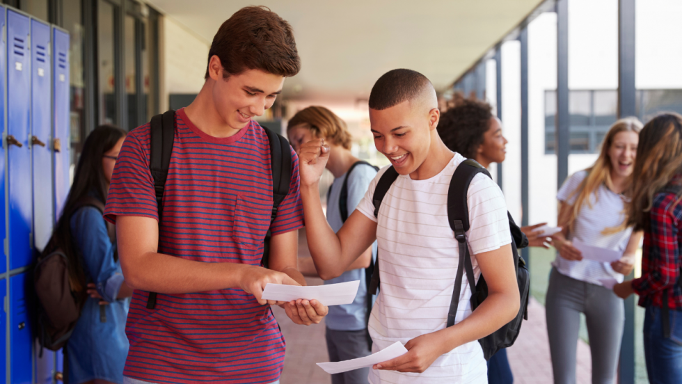 two happy young people reading exam results together