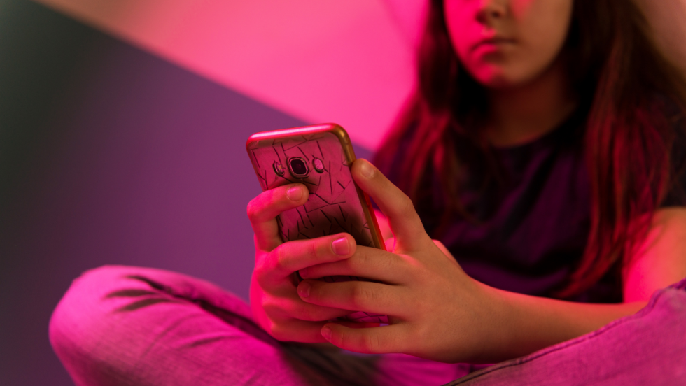 Young person sat down using phone