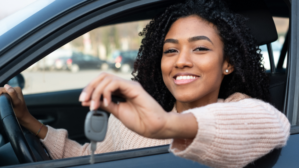 young person sat in a car holding car keys