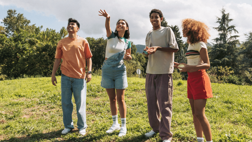 four teenagers stood outside together