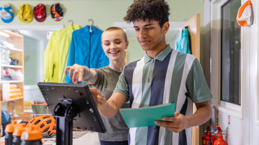 two apprentices using a till