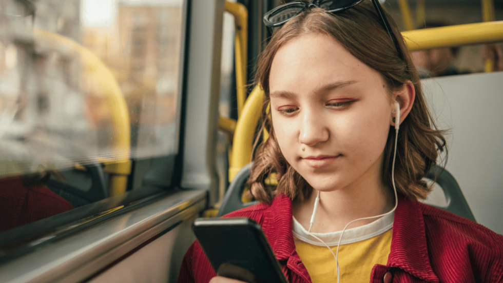 young person on bus using phone