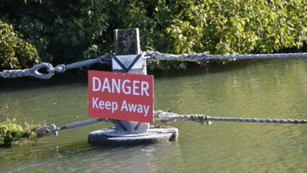 Danger keep away from water sign on river 
