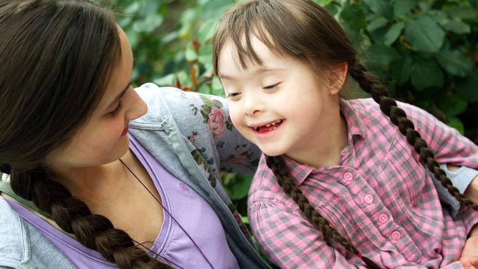 Girl looking after a younger, disabled sister