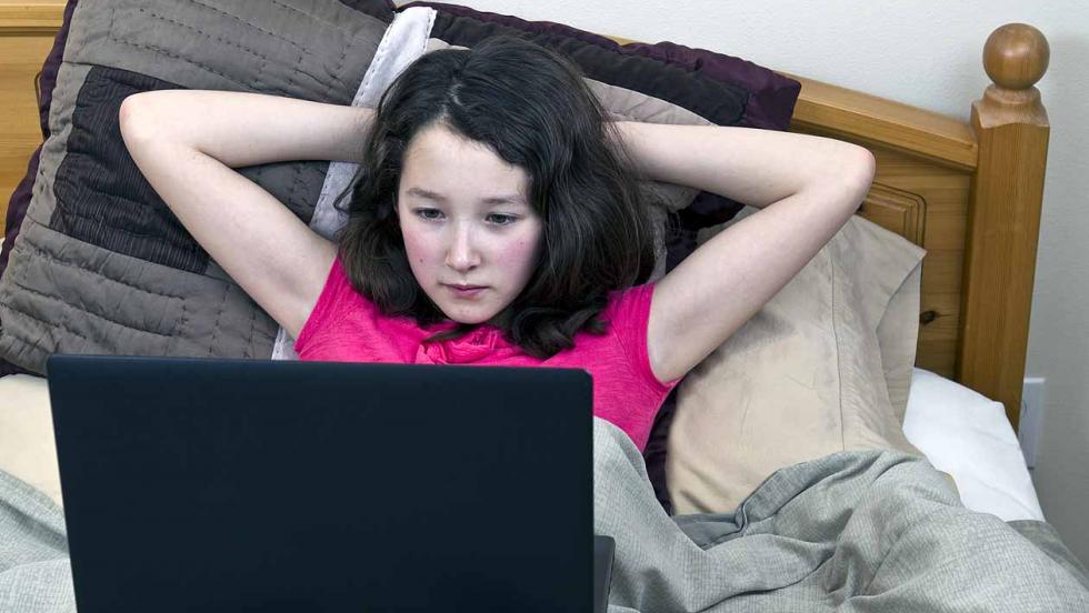 Girl on computer in bed