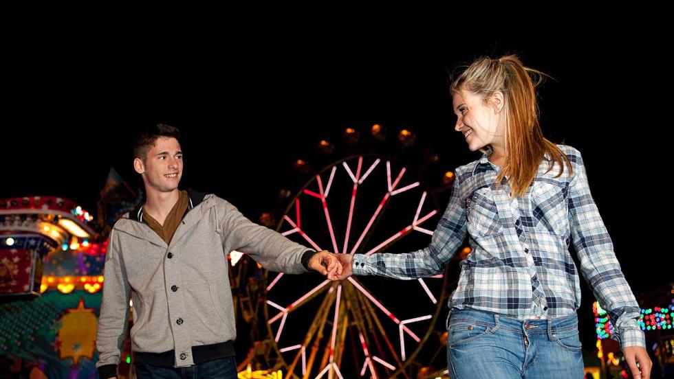Young man and young woman visiting a fairground