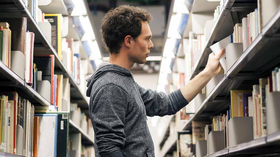 Young man selecting a library book