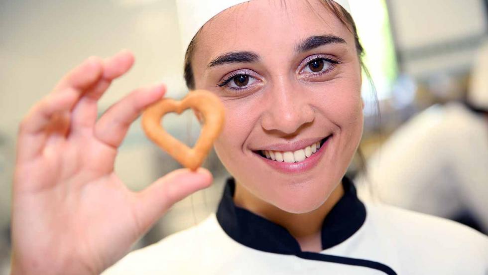 Young chef holding a pastry