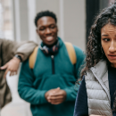 Two teenagers laughing at another teenager