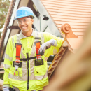 Apprentice builder wearing a hi vis jacket and safety helmet smiling for the camera