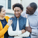 Happy young person stood with two parents