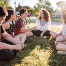 Six young people sat in a field talking