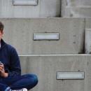 teen sat on steps using phone