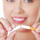 Smiling woman snapping a cigarette in two
