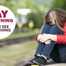 Child sat on a railway platform hiding her face